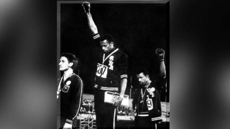 Tommie Smith (center) and John Carlos (right) on the podium at the 1968 Mexico Olympics.