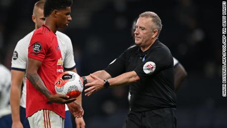 Referee Jonathan Moss takes the ball to Marcus Rashford after he wrongly awarded a penalty.