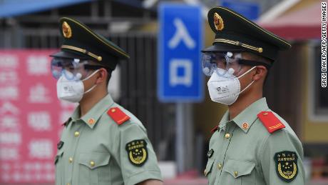 Paramilitary officers wear masks and goggles as they stand guard at the entrance to Xinfadi Indoor Market in Beijing on June 13th.