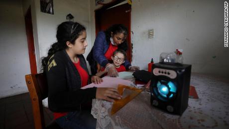 The family listens for an hour to radio lectures from their home in Funza, Colombia, where they have no internet connection.