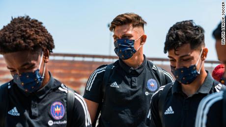 Members of the Chicago Fire FC don masks on their way to training.