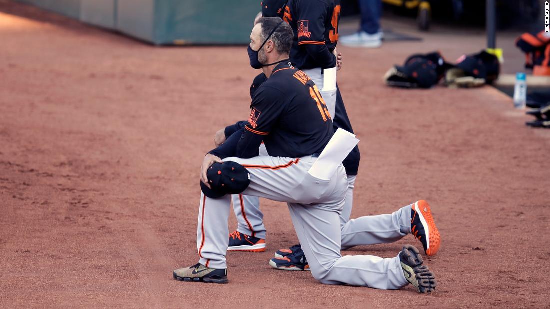 San Francisco Giants' players and manager kneel during national anthem in exhibition game against Oakland