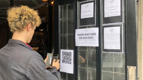 Plastic screens, search applications and service tables. English pubs reopen on a bitter day