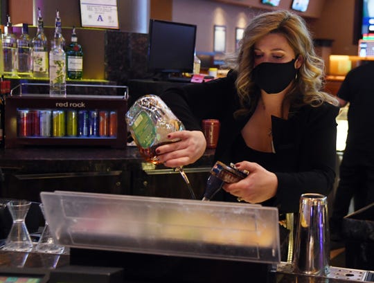 Maria Mahula wears a mask as she makes a drink June 4 at the Red Rock Resort in Las Vegas.