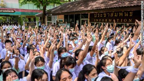 Students perform a three-toed salute at Samsen School to demand less strict school rules and more tolerance and respect during a protest in Bangkok on October 2, 2020.