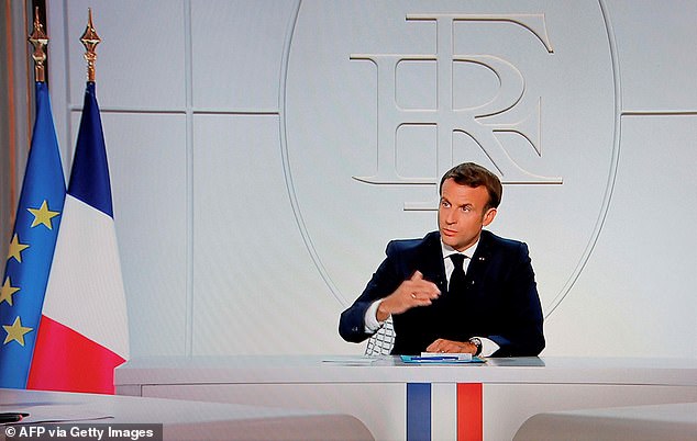 French President Emmanuel Macron addresses the nation during a televised interview from the Elysee Palace, announcing that Paris and eight other major cities will now shut down for nine hours from 9 PM to 6 AM, in an effort to slow the spread of Covid-19 which will last for one month.