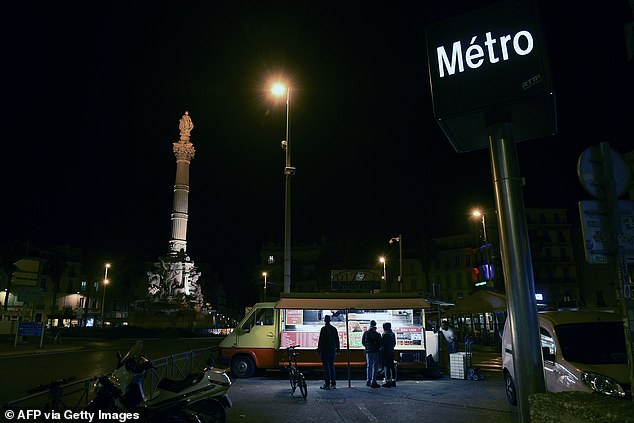 People gather around a street food truck in Marseille, southeast France, before curfew