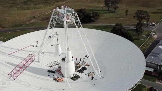 Work crews carry out important upgrades and repairs to the 70 meter (230 ft) radio antenna in Deep Space Station 43 in Canberra, Australia.  In this segment, one of the antenna's white feed cones (which houses parts of the antenna receivers) is driven by a jack.  (Credits: CSIRO)