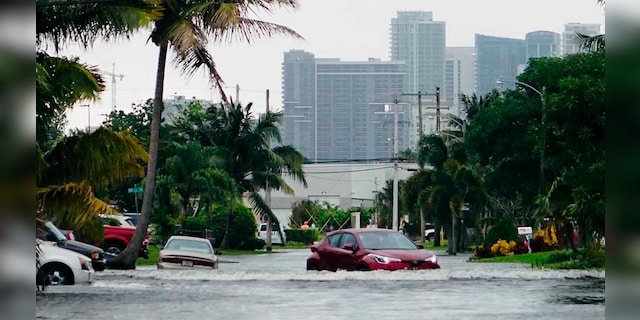 A car drives down a flooded street in the Melrose Manors neighborhood west of downtown Fort Lauderdale on Monday, November 9, 2020.