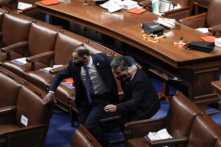 Parliamentarians in House conference rooms bow their heads to search for hiding places as Trump supporters flood Parliament.  Photo: AP.