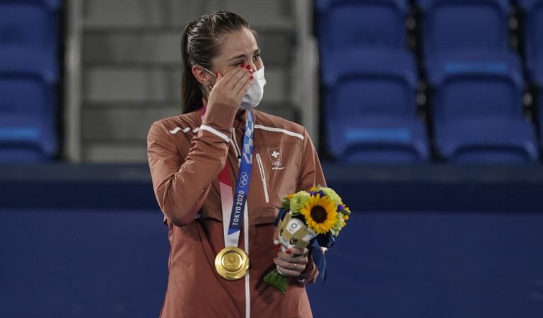 La suiza Belinda Bencic llora en el podio tras recibir la medalla de oro en el tenis individual de los Juegos Olímpicos, el domingo 1 de agosto de 2021, en Tokio (AP Foto/Seth Wenig)