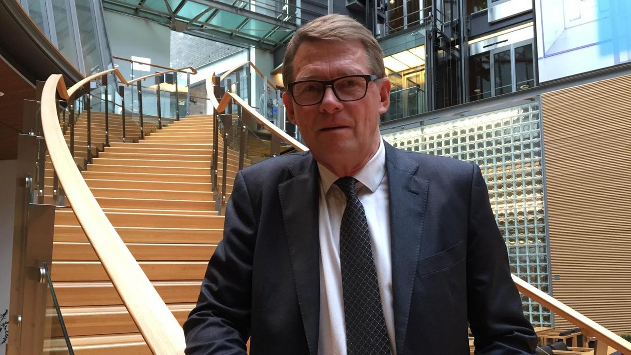 Matti Vanhanen standing next to a staircase in the Helsinki Parliament