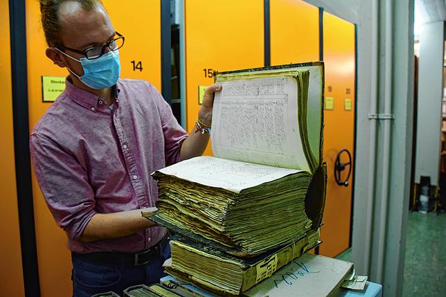 City Archives employee Christopher Vangenheim flips over a huge amount of bills.