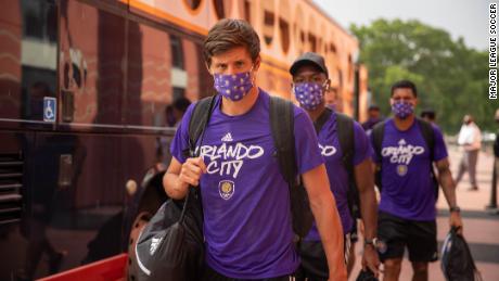 Players from Orlando City leave the team bus before training.