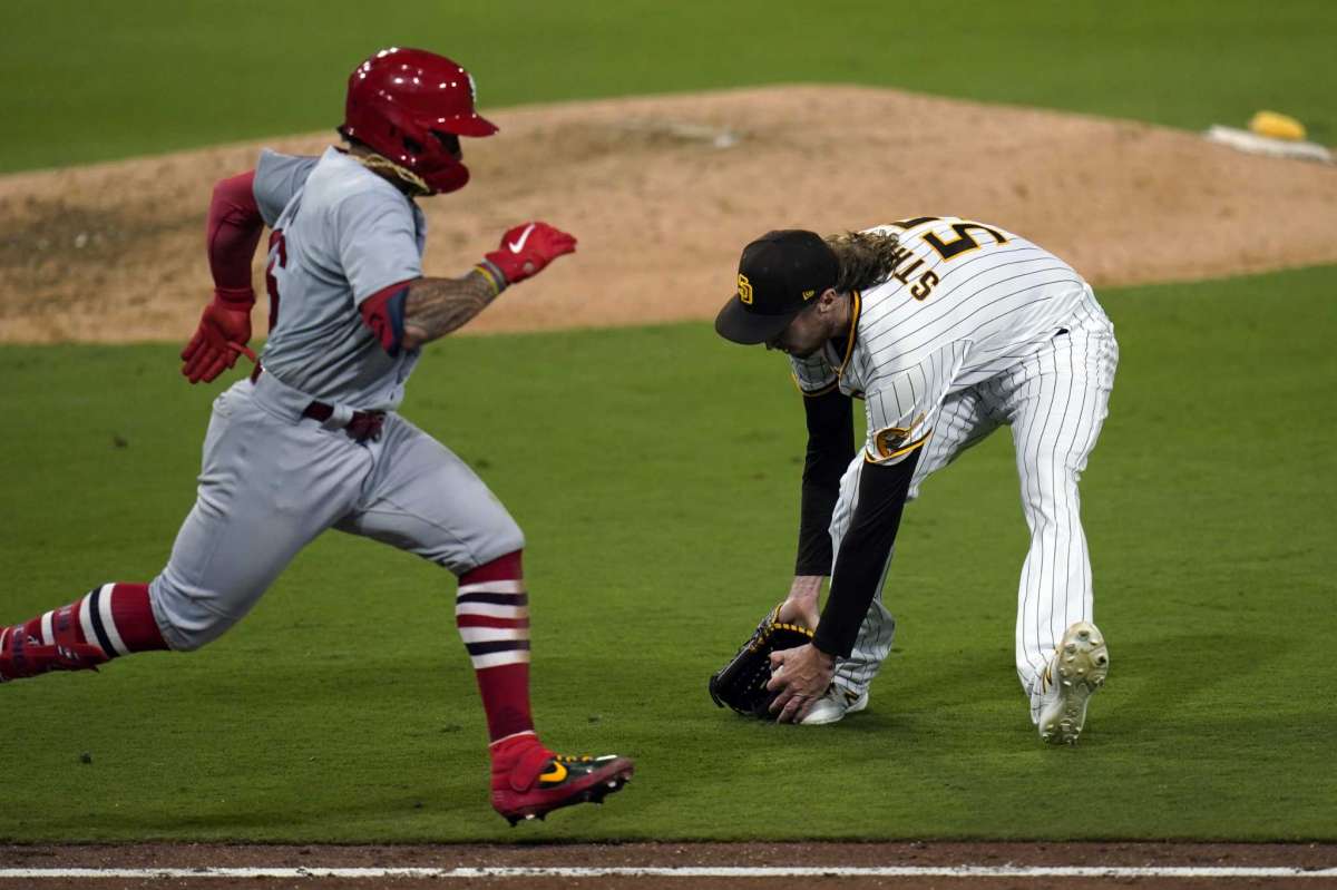 Rams San Diego Padres Matt Straham, right, picks up the ball before Colton Wong throws the St. Louis Cardinals, left, during the sixth game of the National League Baseball Series second match, Thursday October 1, 2020, in San Diego.  Cardinals' Matt Carpenter scored third in the play.