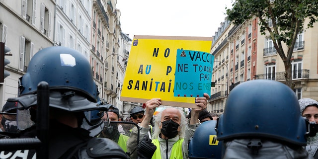 Anti-vaccination protesters confront police during a protest against passports and vaccines, in Paris, France, Saturday, August 7, 2021.