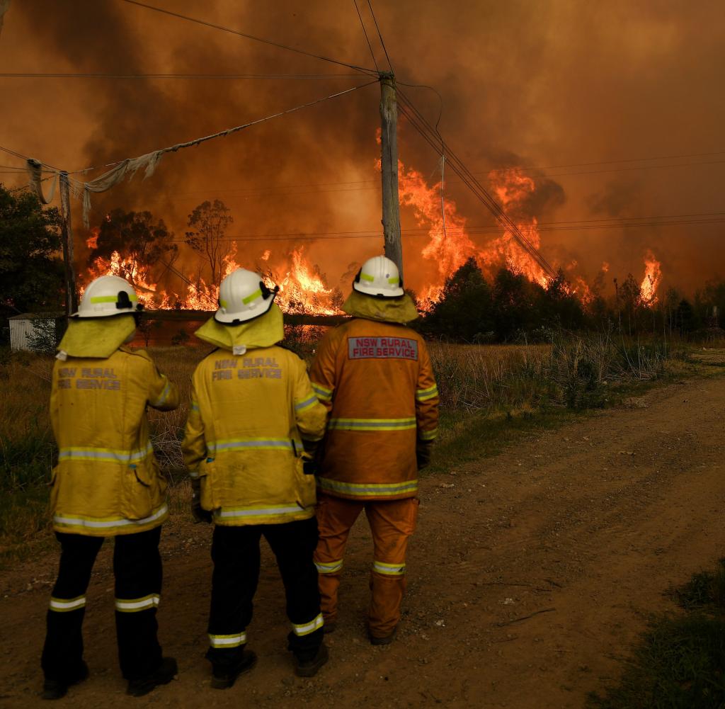 Australian firefighters monitor a farm fire in December